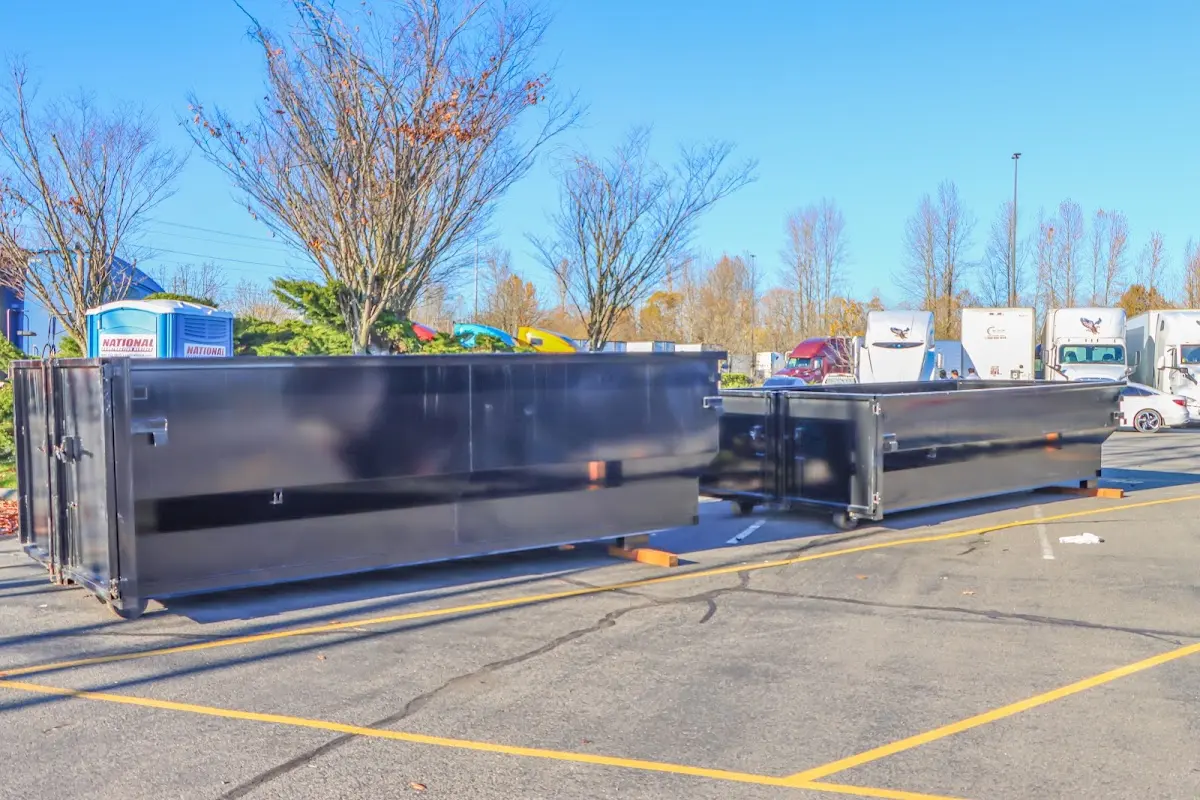 Professional dumpster rental service with roll-off container on residential driveway in Holdrege